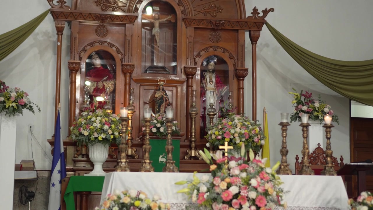 Chiesa cattolica tradizionale latinoamericana con un grande altare in legno e composizioni floreali. Honduras