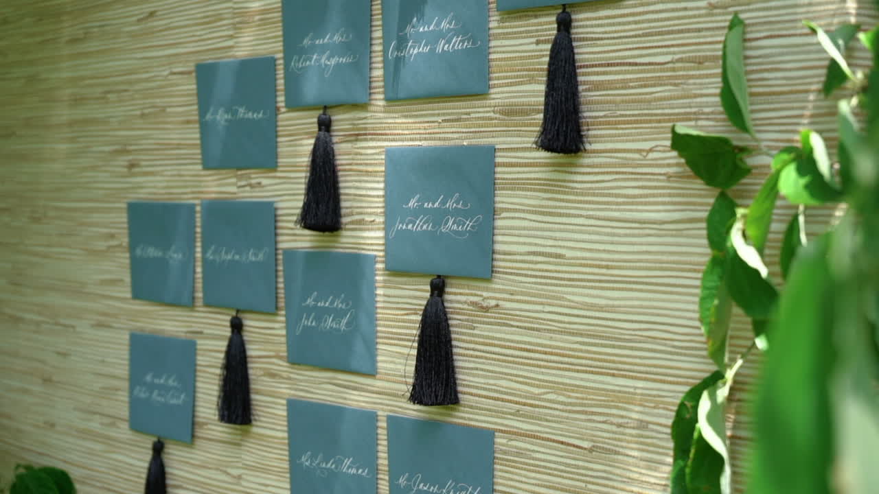 Slider shots from hanging tree branch to a board of wedding guest invitations, thank you notes, or seating selections