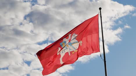 bandera lituana histórica con escudo de armas ondeando en el viento