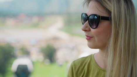 mujer positiva con gafas de sol mira a la cabina del ascensor poma