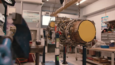 mechanics working on an airplane engine in a garage