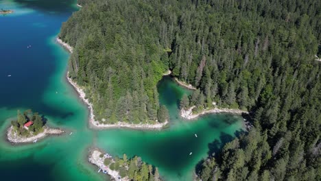 helicóptero disparado sobre eibsee baviera baviera alemania turquesa verde azul color claro aguas poco profundas lado del lago playas y bosque de pinos en las tierras altas de la montaña maravilloso paisaje escénico avión no tripulado verano