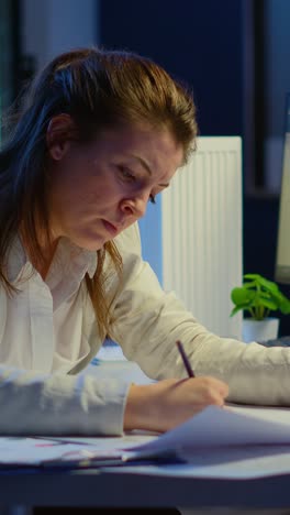 vertical video: overworked woman architect analysing and matching blueprints