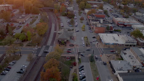 aerial view of main street and train tracks in downtown kirkwood, missouri at sunset in autumn with a tilt down