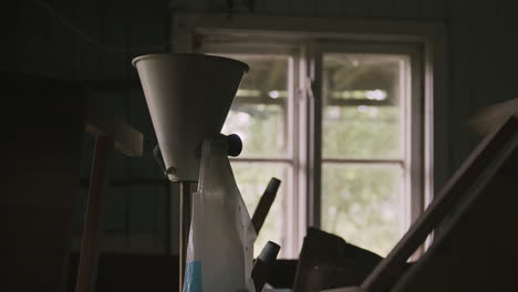 detailed view of a vintage lamp amidst clutter with natural light from a broken window.