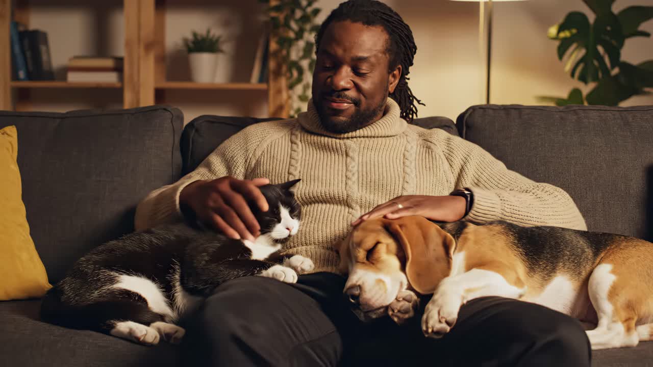 Man relaxing with his cat and dog on the couch