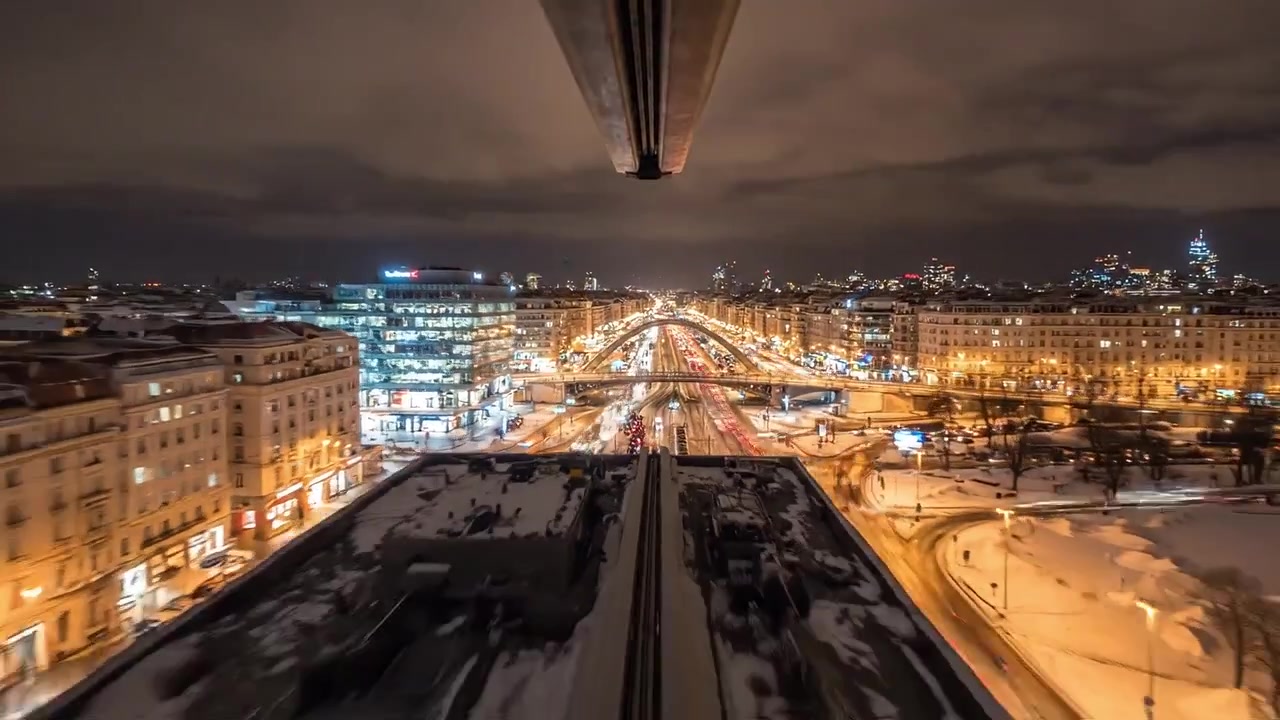 Nighttime Cityscape Showing Busy Traffic and Snow-Covered Roads with Glowing Streetlights and Urban Landscape in a Beautiful Winter Environment