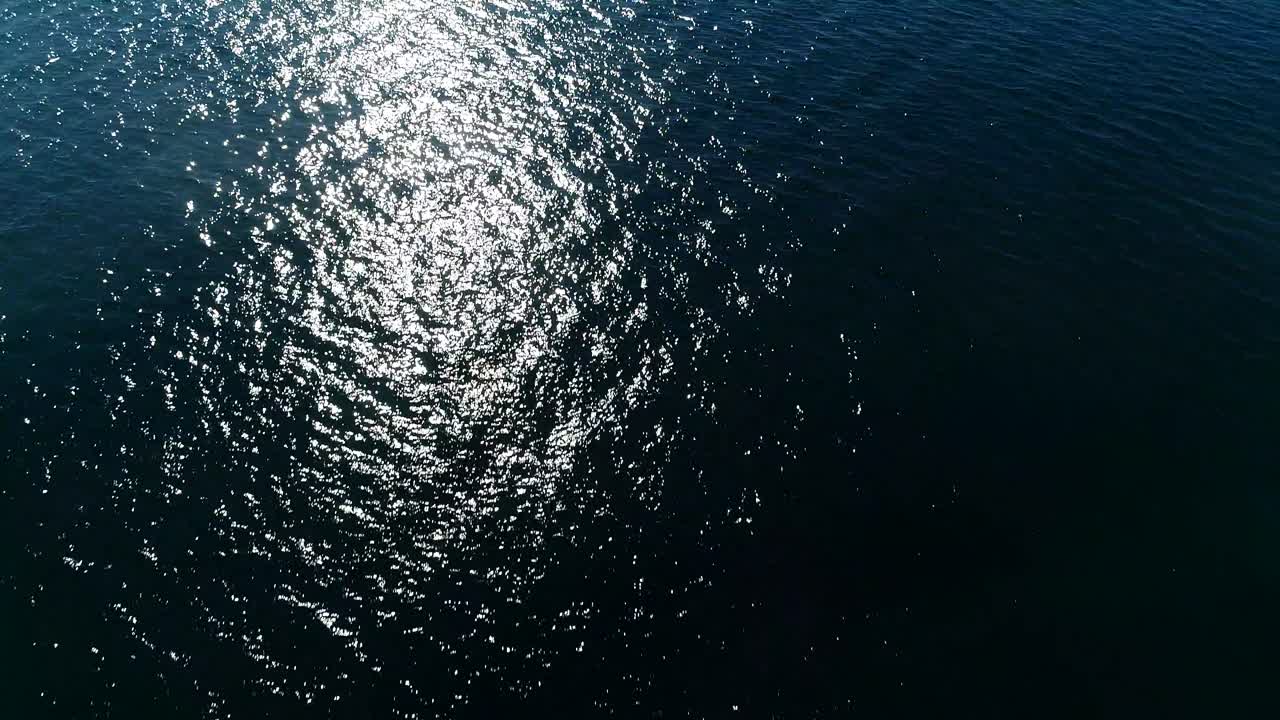 flying over calm ocean on sunny day