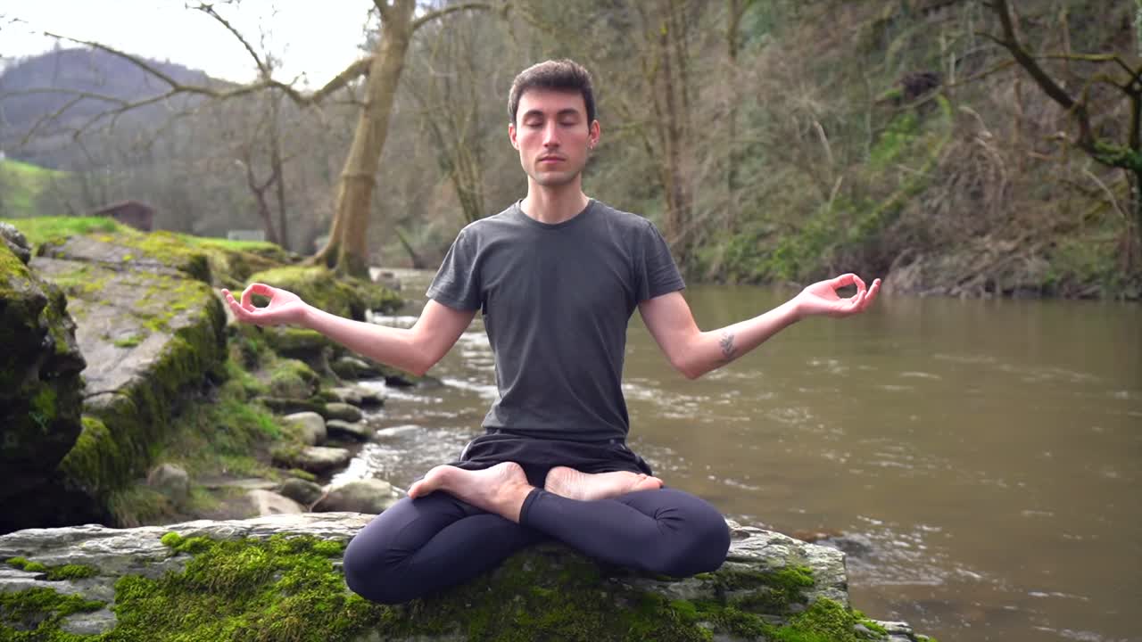 Man Meditating in Nature by the River