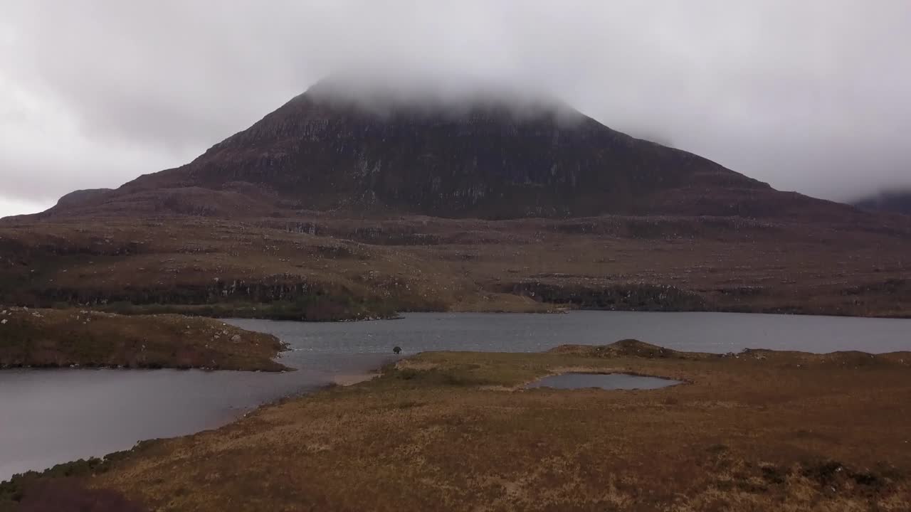 Mountain reveal flight over a lake during winter in Scotland.