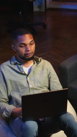 vertical video black man joining online lesson to work on new skills from home space