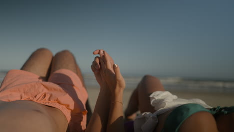 Young-couple-sunbathing-at-the-beach