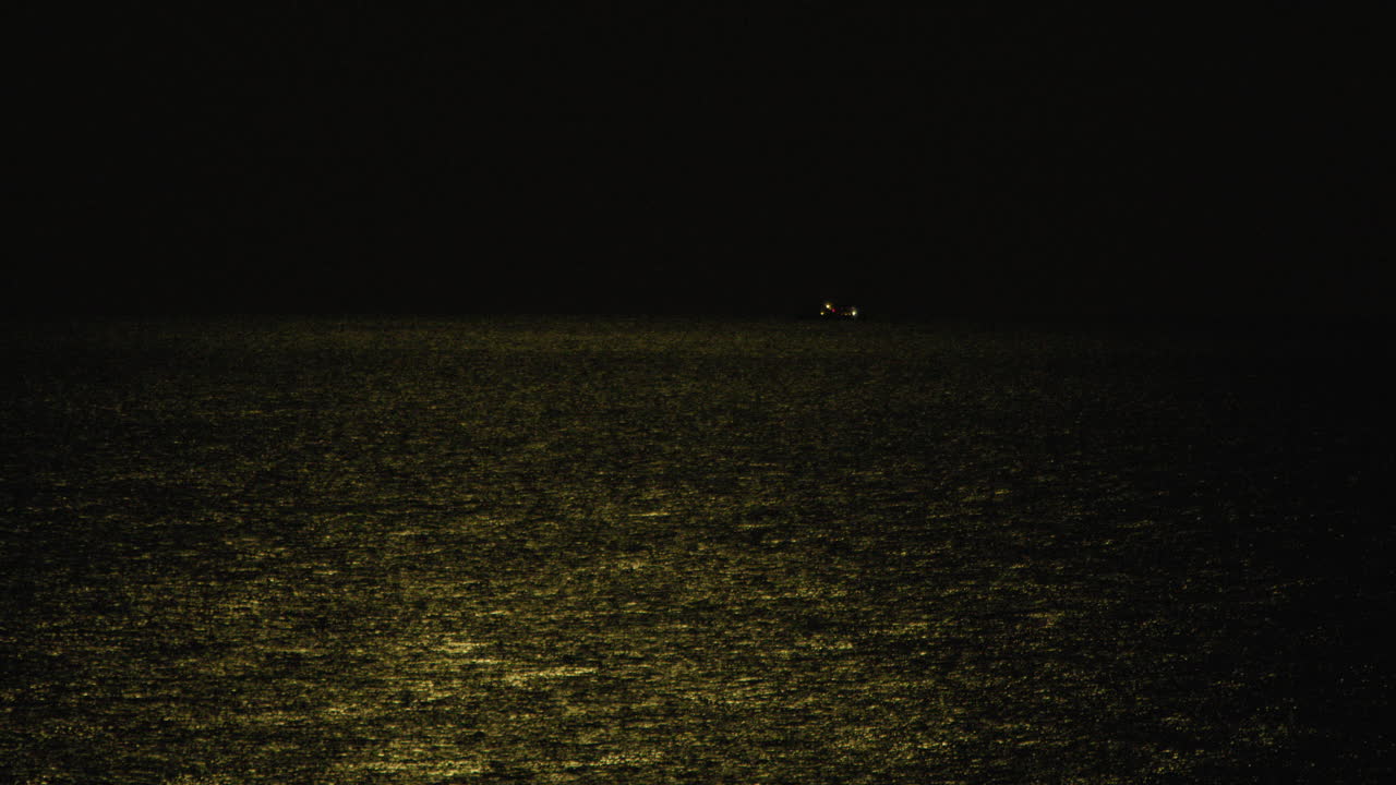 Sicilian Sea At Night With The Faint Light Of The Moon Illuminating The Surface