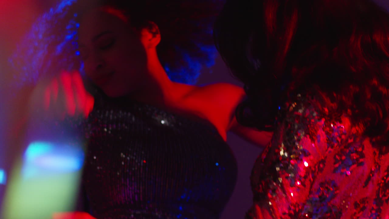 cerca de dos mujeres en un bar de club nocturno o discoteca bailando con luces brillantes 14