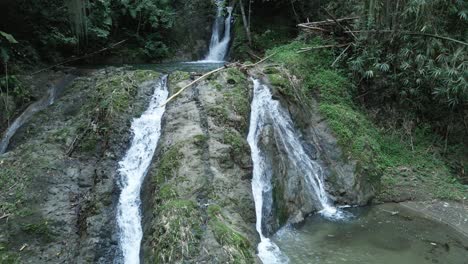 Increíble-Paso-Elevado-En-Cámara-Lenta-De-Una-Joven-De-Pie-En-La-Base-De-Una-Cascada