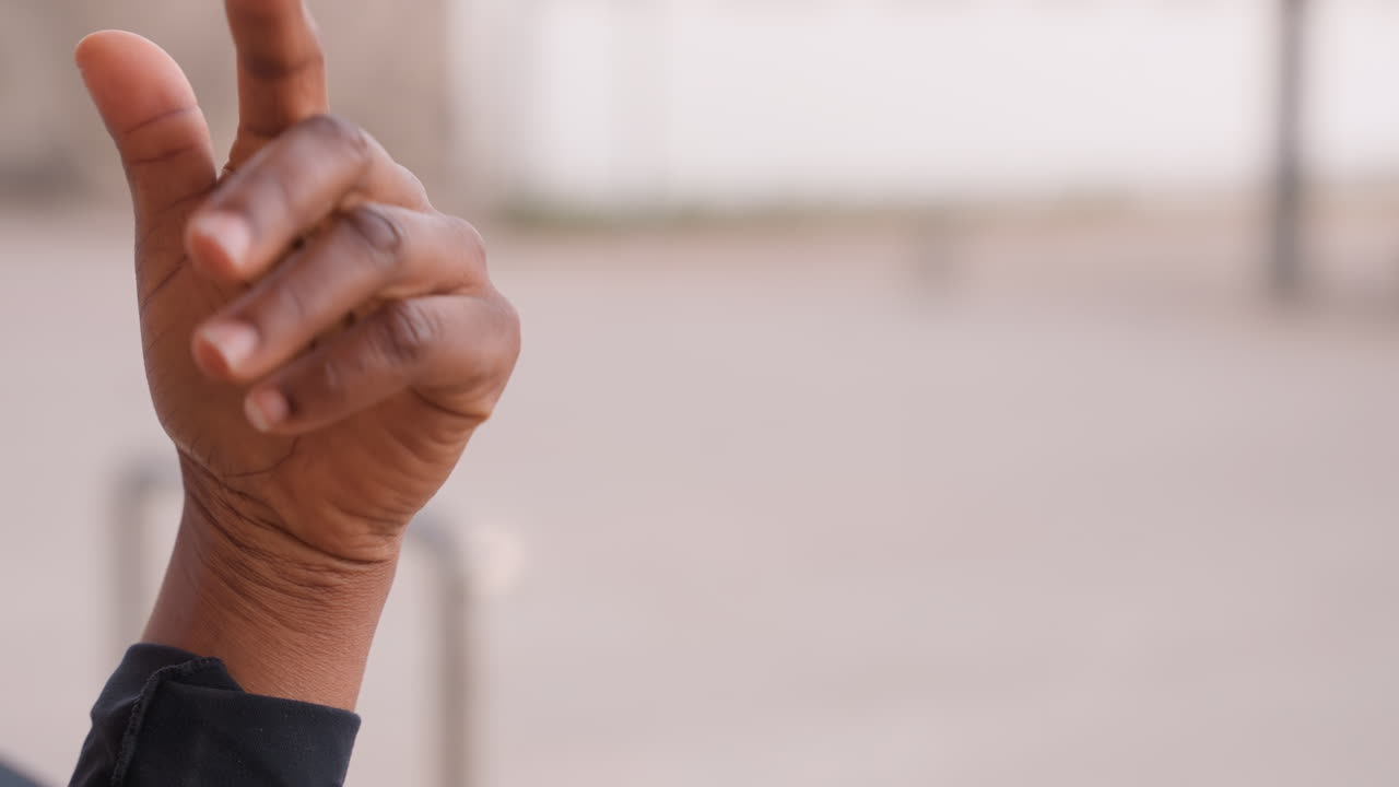black woman hand gestures closeup, sequence of pointing, beckoning and counting movements, textured skin and braided wrist against blurred urban backdrop, intimate study of dexterity, rhythm