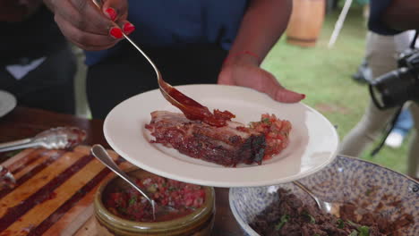 a lady pouring sauce onto steak at a buffet