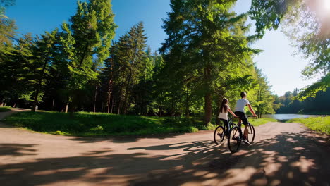 couple biking on a forest trail by the lake