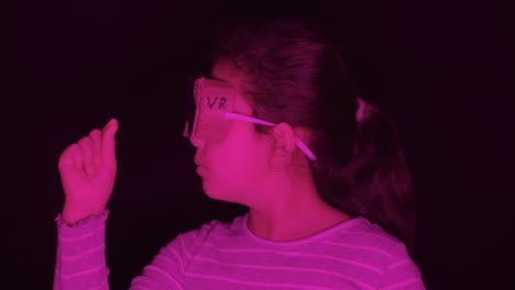 girl wears fake cardboard vr headset and imagines virtual reality in strong magenta light