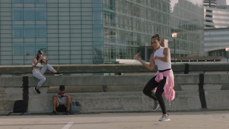 Mujer-Bailando-Joven-Bailarina-De-Hip-Hop-Realizando-Movimientos-De-Estilo-Libre-Amigos-Multiétnicos-Viendo-Disfrutar-De-La-Práctica-De-Danza-Urbana-Usando-Un-Teléfono-Inteligente-Tomando-Videos-Compartidos-En-Las-Redes-Sociales