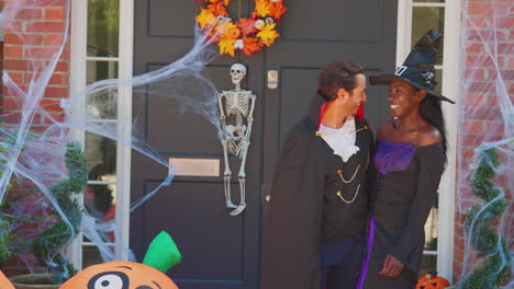 couple dressed up for halloween outside house ready for trick or treating