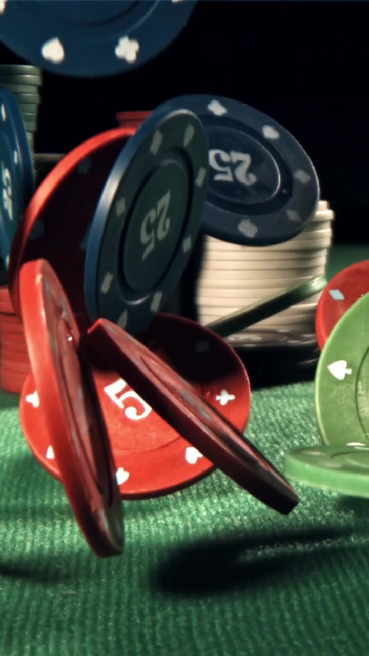 Żetony pokerowe spadające na zielony stół kasynowy w zwolnionym tempie
