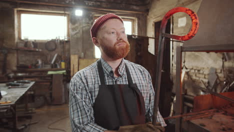 blacksmith putting wrought iron rod in fire