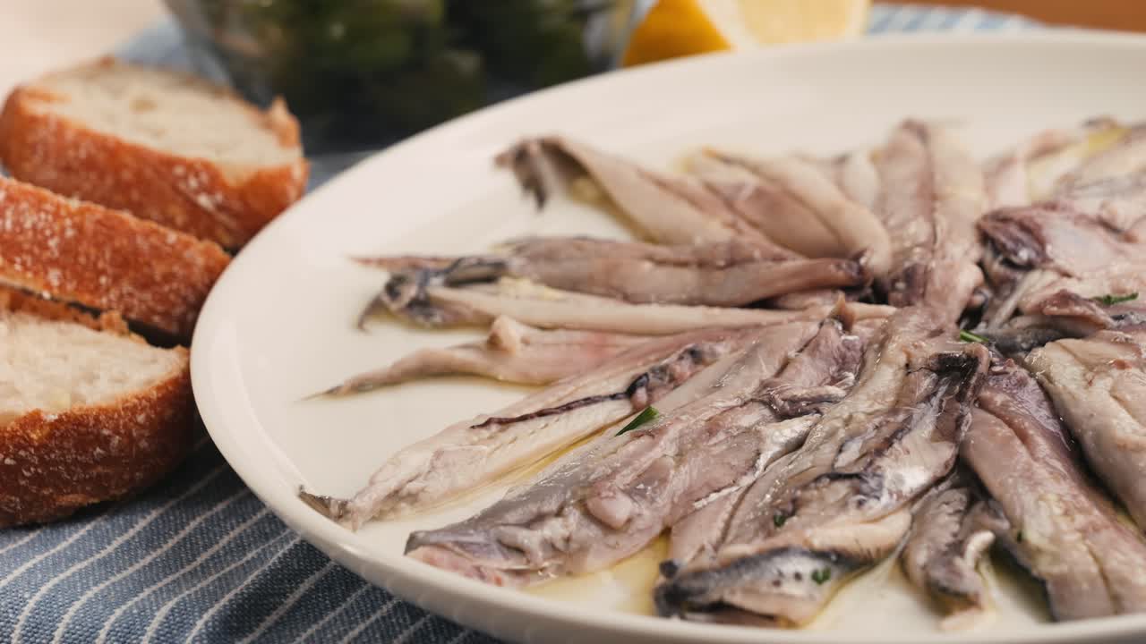 Fresh Sea sardines and Anchovy Fish and Mullus On Display On Ice On Market Store Shop. Seafood Fish Background, close up stand of small salty white fish.