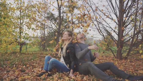 una pareja disfrutando de las hojas de otoño en el parque