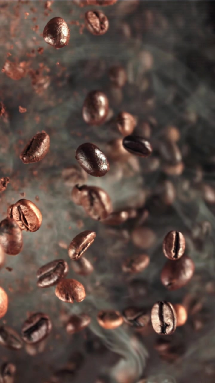 Chicchi di caffè tostati in caduta al rallentatore con fumo che sale