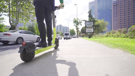 pies de hombre de negocios usando scooter eléctrico.