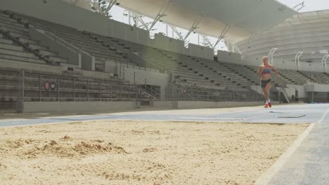 caucasian athlete doing long jump