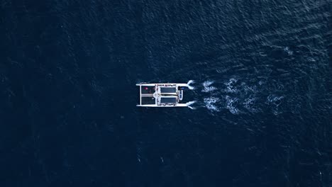 Katamaran-Isoliert-Im-Tiefblau-Schimmernden-Wasser-Des-Ozeans,-Der-Die-Schönheit-Der-Natur-Erkundet