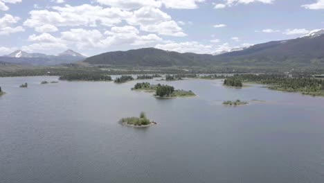 drone pass over small inland with people pushing off in a canoe