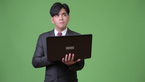 젊은 잘생긴 아시아 사업가 노트북을 사용