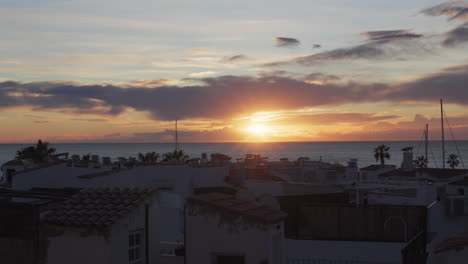 time-lapse of fishing village rooftops during sunrise over the sea