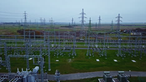 avión no tripulado que se eleva frente a una subestación de transmisión eléctrica, día oscuro y nublado