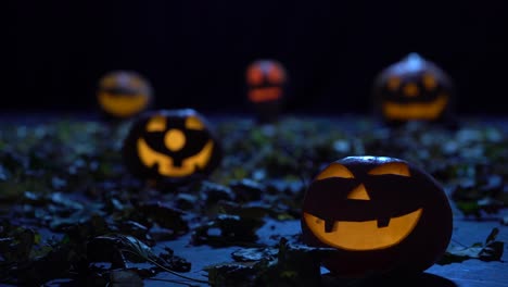 scary pumpkins on halloween in the dark forest are burning like lanterns