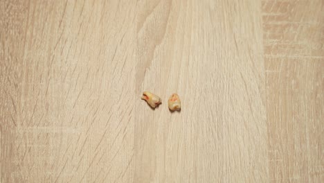 two newly extracted wisdom teeth on a wooden table