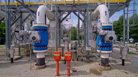 a trucking shot moves through a modern natural gas pumping station in latvia, showing the complex pipes, valves, and infrastructure used for the transport and distribution of energy