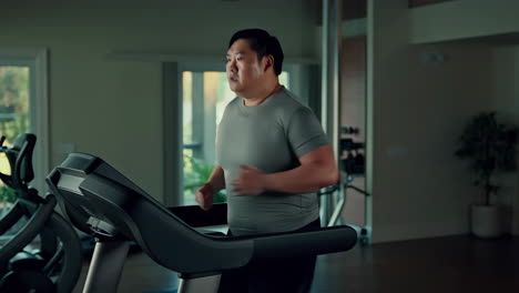 체육관 에서 트레드밀 을 달리는 남자