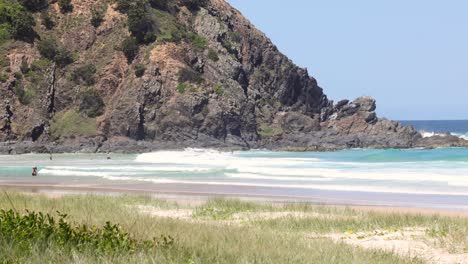 a tranquil beach scene with waves and cliffs.
