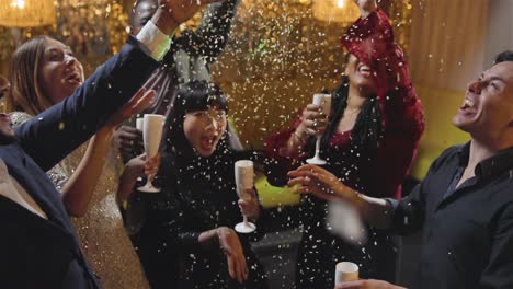 high angle shot of a group of friends celebrating new years eve with confetti