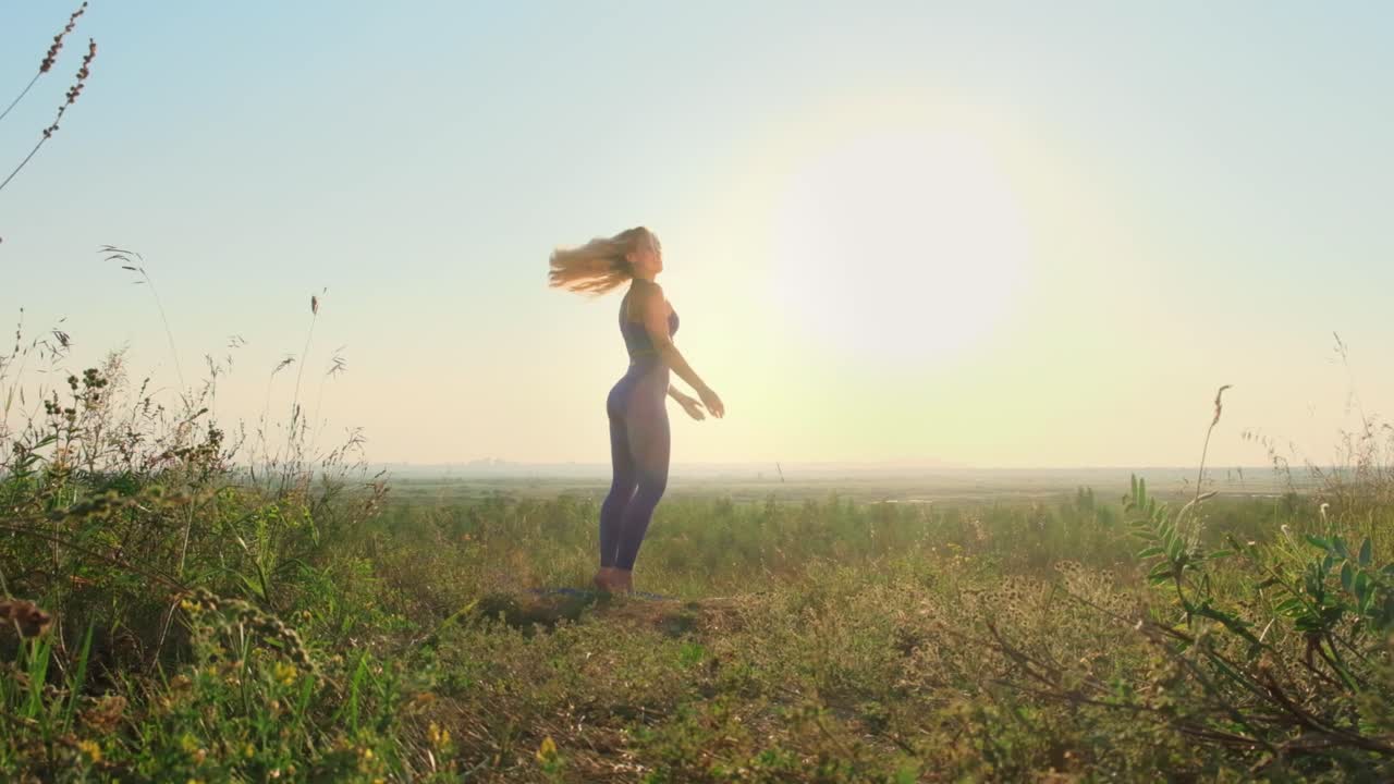 Donna che pratica yoga all'aperto al tramonto
