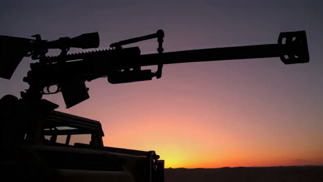 military sniper rifle silhouette at sunset in the desert