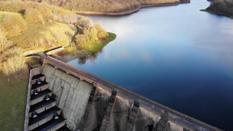 Linksschwenk-Eines-Wimbleball-Seedamms-Und-Eines-Ruhigen-Sees,-Der-Den-Himmel-An-Einem-Schönen-Sonnigen-Abend-Widerspiegelt