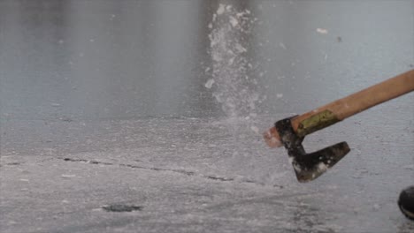 Breaking-the-ice-of-a-frozen-lake-with-an-axe-in-slow-motion