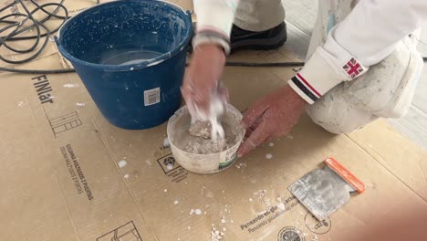 person is preparing paint mass to fill fine hole details in the walls, preparation for later adding to walls to fill fine hole surface, repairing and maintaining indoor house concept