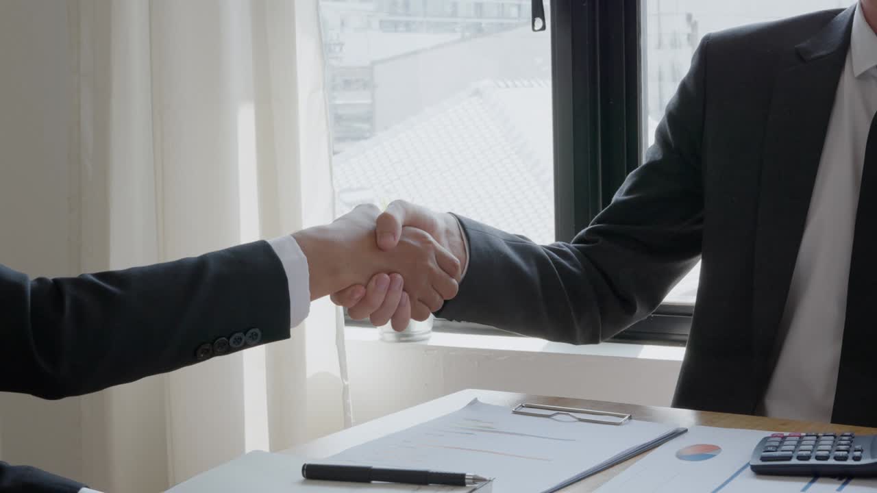 представитель по продажам пожимает руки и доставляет ключи новым домовладельцам после завершения соглашения о покупке и продаже. концептуальный контракт.