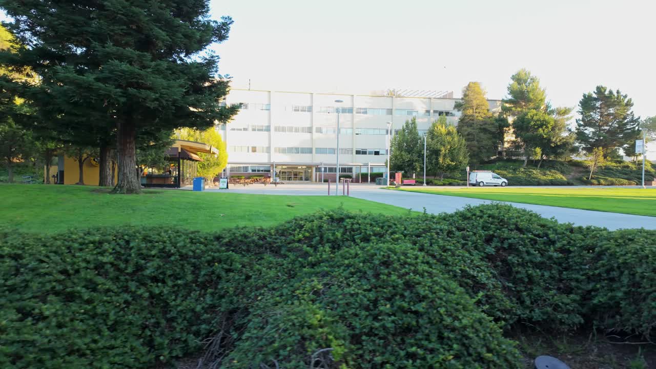 Panning view through CSU East Bay offers a dynamic look at glass-fronted buildings and landscaped quads
